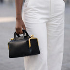 A luxurious designer bag for women with a two-sided clamp frame and a kiss lock.