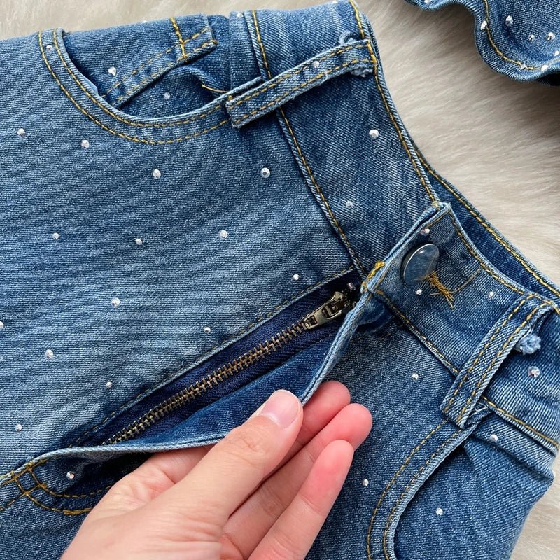 A stylish women’s summer outfit featuring a versatile sleeveless strapless vest with rhinestones and high-waisted denim trumpet pants.