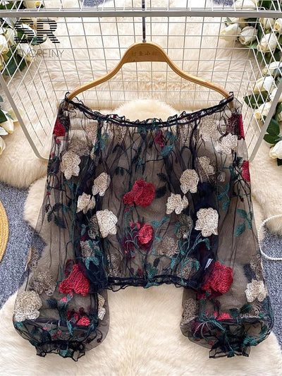 This sexy, versatile women’s blouse features a thin, off-shoulder design with sheer, romantic embroidery. It’s perfect for various occasions and adds a touch of feminine elegance to any outfit.